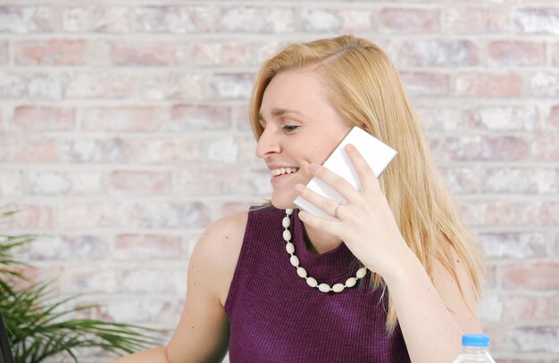 Schöne junge Geschäftsfrau, die am Telefon spricht