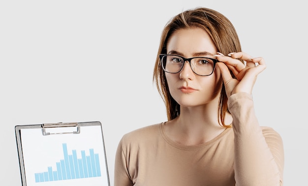 Schöne junge Geschäftsfrau, die Brille lokalisiert auf grauem Hintergrund trägt.