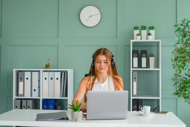 schöne junge Geschäftsfrau, die im Büro am Laptop arbeitet