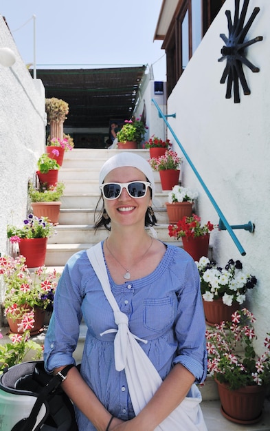 Schöne junge griechische Frau in modischer Kleidung hat Spaß in den Straßen von Oia, Santorini, Griechenland