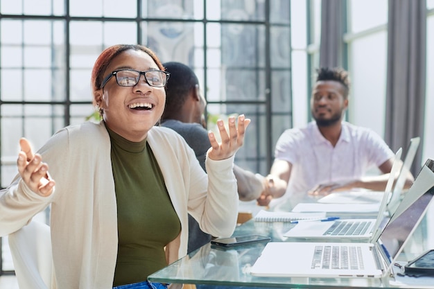 Foto schöne junge grinsende professionelle schwarze frau im büro