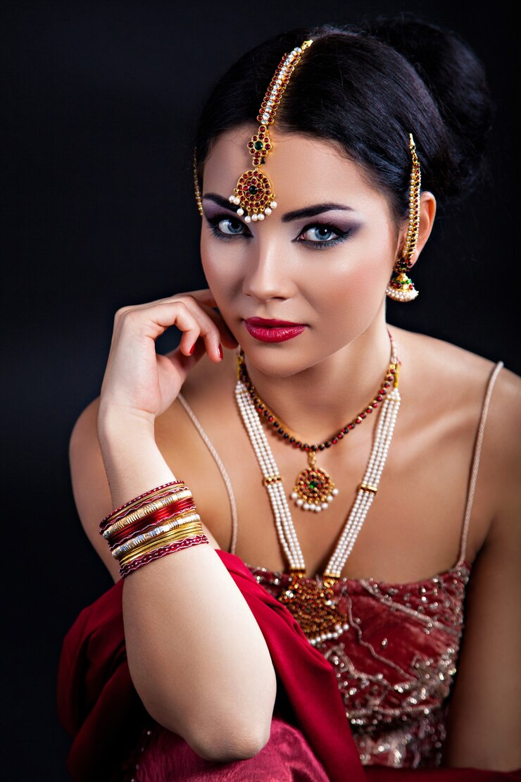 Schöne junge indische Frau in traditioneller Kleidung und indischem Zubehör