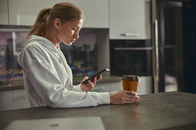 Schöne junge kaukasische Dame, die an der Küche arbeitet