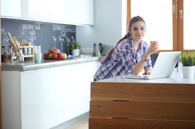 Schöne junge lächelnde Ärztin, die am Schreibtisch sitzt und schreibt