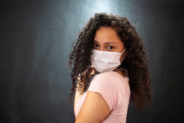 Schöne junge Latina mit einer medizinischen Maske