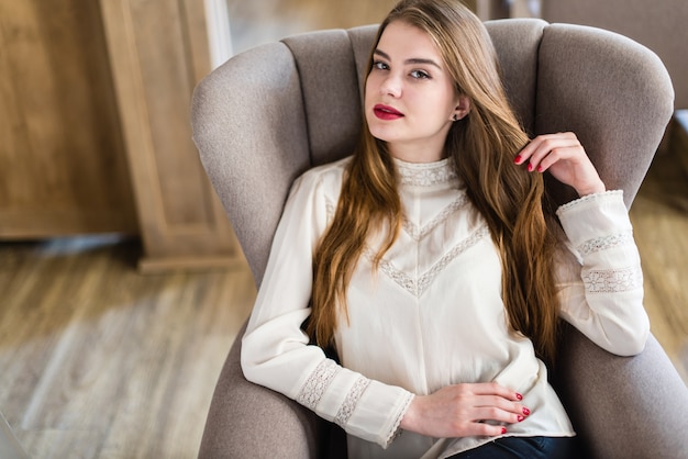 Schöne junge Mädchen mit professionellen Make-up und Frisur sitzen im Restaurant.