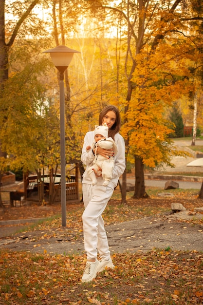 Schöne junge Mutter mit Baby im Herbst