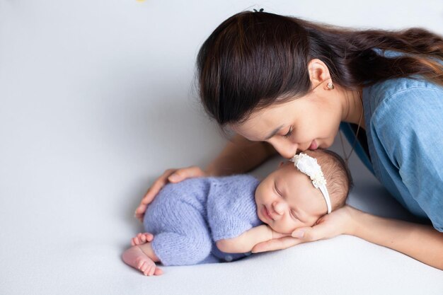 Schöne junge Mutter mit einer neugeborenen Tochter in einer Windel auf weißem Hintergrund Zärtlichkeit der Mutterschaft Platz für Text