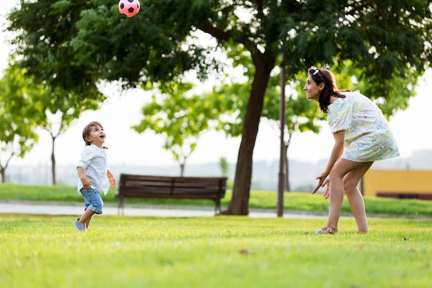 Schöne junge Mutter mit ihrem Sohn Spaß im Park.