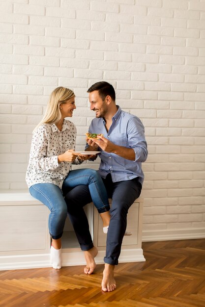 Schöne junge Paare, die Pizza essen