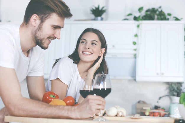 Schöne junge Paare, die zusammen eine gesunde Mahlzeit zubereiten, während sie Freizeit zu Hause verbringen.