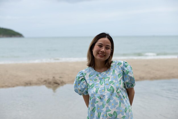 Schöne junge schwangere Frau, die am Strand spazieren geht, fühlt Frieden