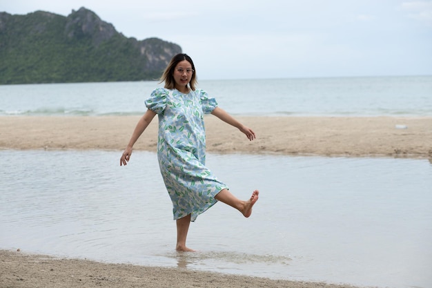 Schöne junge schwangere Frau, die am Strand spazieren geht, fühlt Frieden