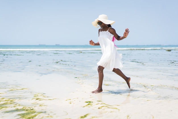 Schöne junge schwarze Afroamerikanerin am tropischen Strand