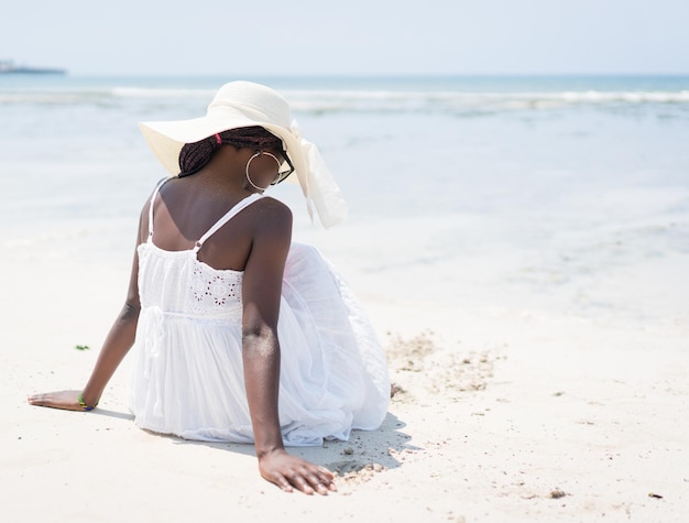 Schöne junge schwarze Afroamerikanerin am tropischen Strand