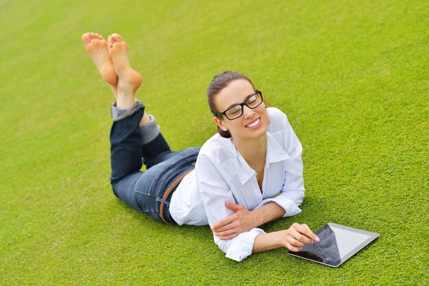 Schöne junge Studentin studiert mit Tablet im Park