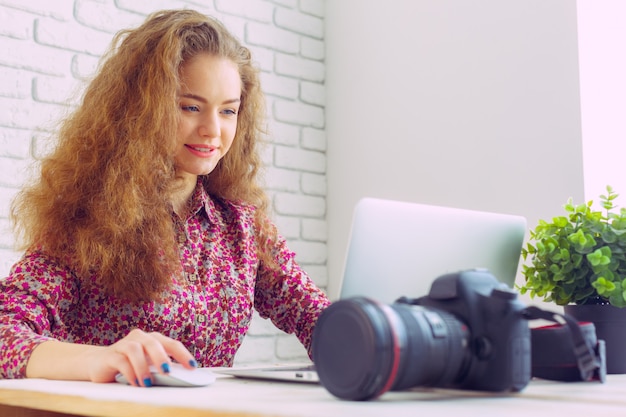 Schöne kaukasische Frau, die an Laptop sitzt und arbeitet