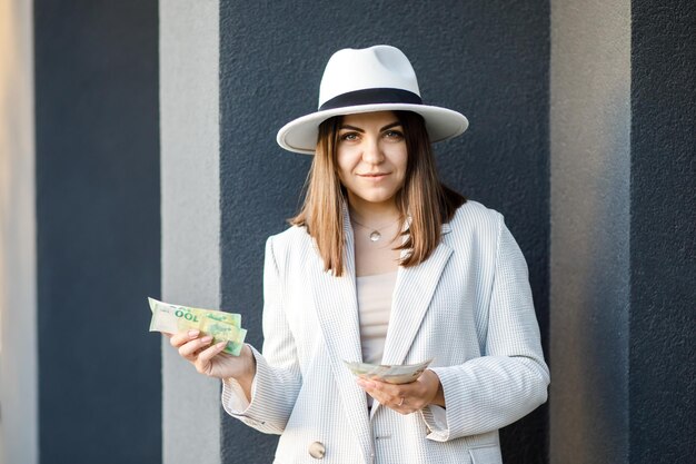 Schöne kaukasische Frau, die Bündel von 50-Euro-Banknoten hält, die mit offenem Mund glücklich lächeln Frau hält Banknoten in ihren Händen