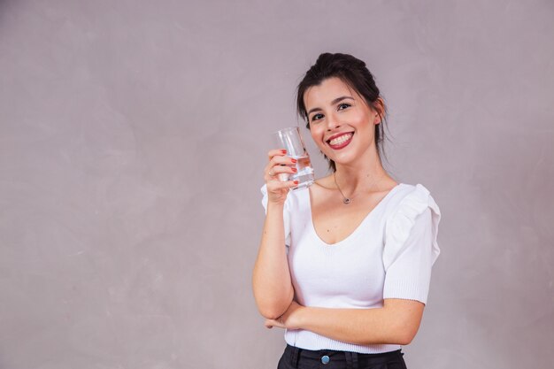 Schöne kaukasische Frau, die ein Glas Wasser trinkt.