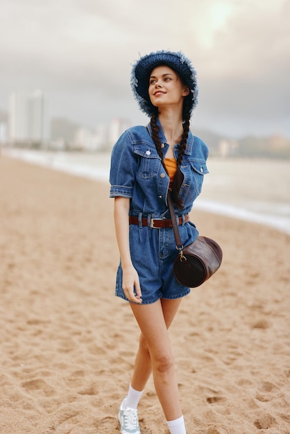 Schöne kaukasische Frau posiert im Freien an einem sonnigen Strand und strahlt Schönheit und Mode in einem trendigen Stil aus