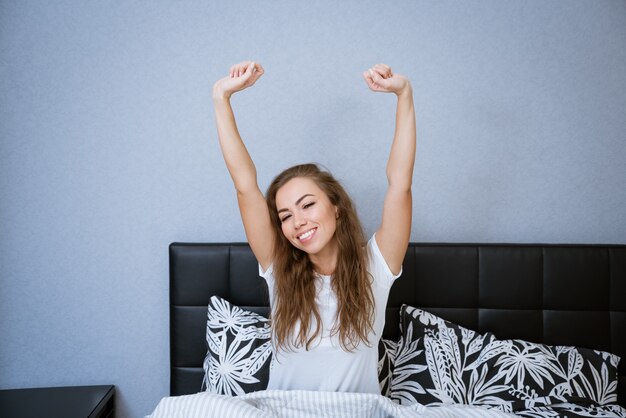 Schöne kaukasische frau zu hause im bett entspannen glückliches lächeln brünette frau schönes modell lässiges leben...