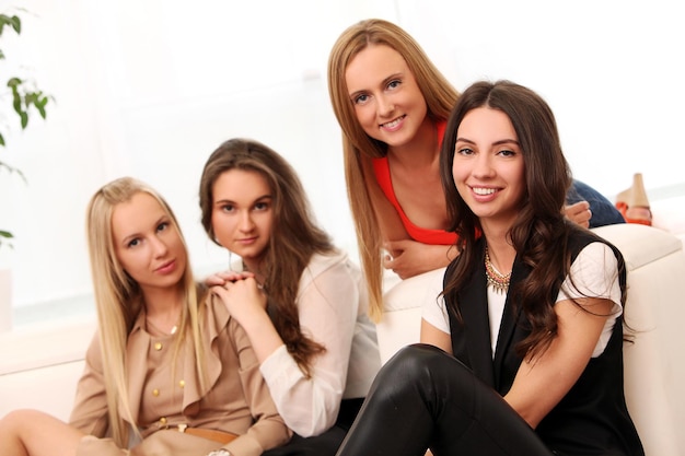 Schöne kaukasische Frauen posieren zu Hause auf einem Sofa