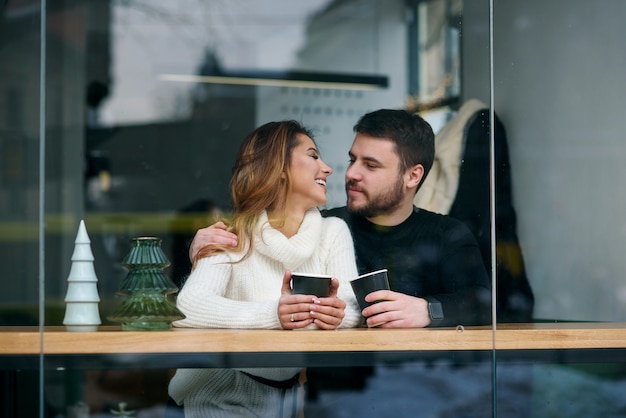 Schöne kaukasische Paare trinken Kaffee auf einem Datum und haben Spaß zusammen.