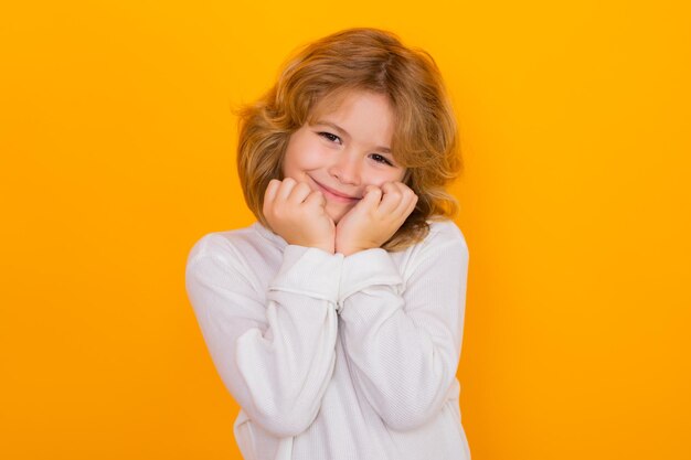 Schöne Kinder-Jungen-Träume auf gelben isolierten Studio-Hintergrund Kinder-Tagträumen und Fantasie Freundlichkeit