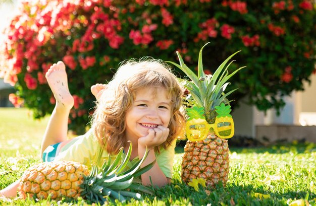 Schöne Kinder mit Ananas, frische tropische Früchte für Kinder, gesunder Lebensstil mit frischen organischen Früchten.