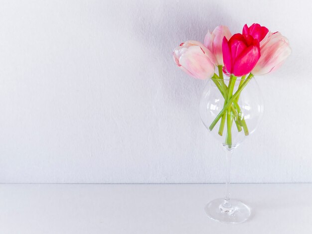 Schöne klare Tulpen im Glas auf weißem Hintergrund.