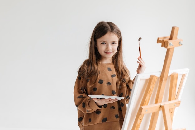 Schöne kleine Malerin auf weißem Hintergrund