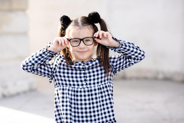 Foto schöne kleine schülerin, 5-6 jahre alt, trägt brille und lässig stilvolles kleid zurück in die schulkindheit