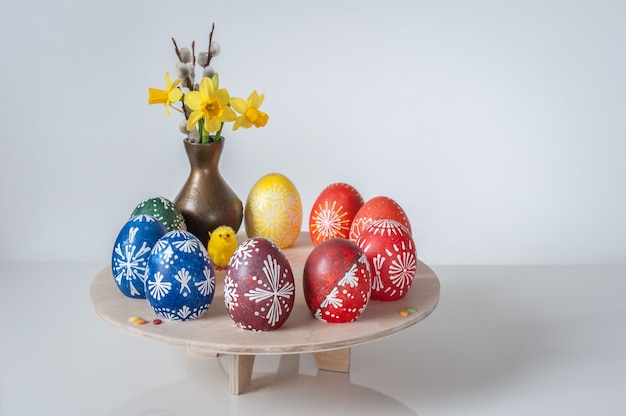 Schöne Komposition mit bemalten Eiern, Weidenruten und einem Blumenstrauß aus Frühlingsblumen