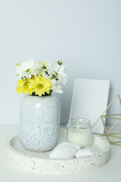 Schöne Komposition mit Chrysanthemen und leerem Fotorahmen auf weißem Tisch.