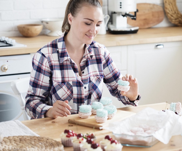 Schöne konditorin macht süße kuchen in der küche