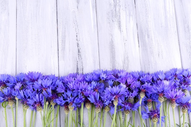 Schöne Kornblumen auf hölzernem Hintergrund