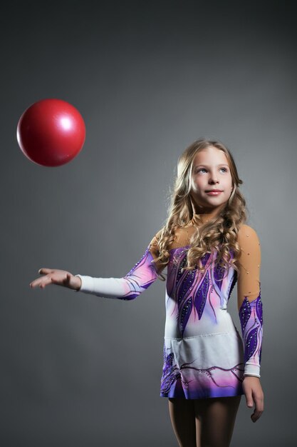 Schöne Kunstturnerin wirft Ball im Studio