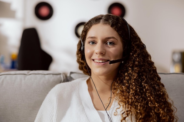 Schöne lächelnde brünette Frau mit Locken, die in einem Hotline-Büro arbeitet, behauptet, in die Kamera zu schauen