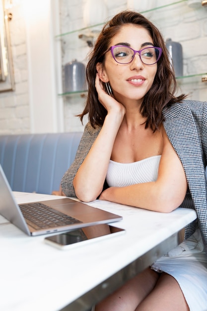 Schöne lächelnde junge Frau mit Laptop in einem Café. Online-Geschäft, Ausbildung und Geschäft.