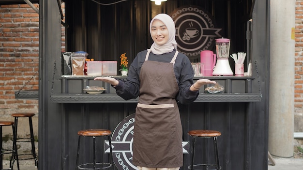 Schöne lächelnde Kellnerin, die bereit ist, Kunden am Café-Standcontainer zu begrüßen?