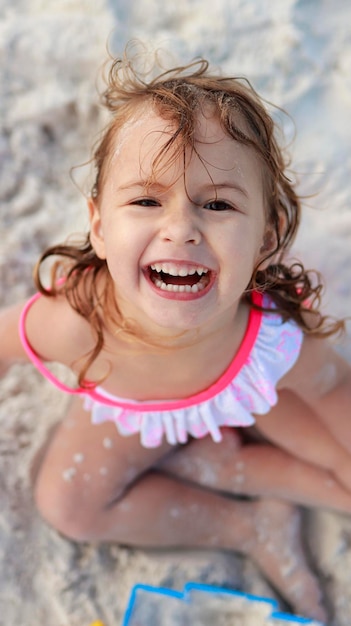 Schöne, lächelnde Kinder in Badeanzügen am Strand, tagsüber mit der Familie, den Tag im Freien.