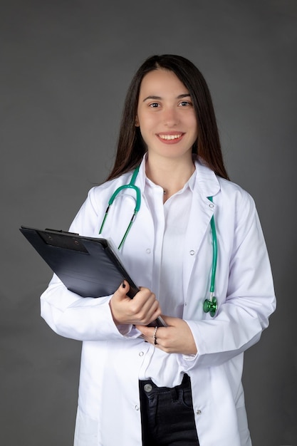 Schöne lächelnde türkische Ärztin mit Patientenakte in ihren Händen