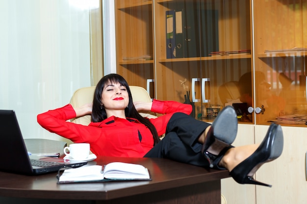 Schöne Lächelnfrau entspannen sich in einem Büro