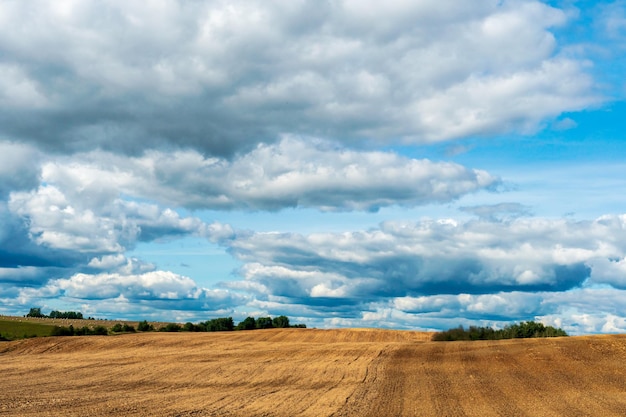 Schöne ländliche Landschaft Hilly gepflügte landwirtschaftliche Felder vor dem Hintergrund der Wolken Das Spiel von Licht und Schatten auf einer hügeligen Landschaft