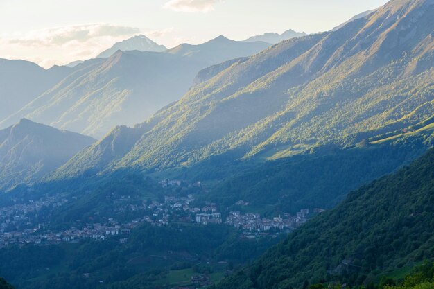 Schöne Landschaft der geschichteten, nebligen, nebligen Bergkette der italienischen Alpen während der abendlichen Lombardei