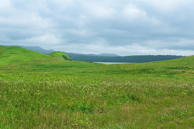 schöne Landschaft der Insel Kunaschir mit grasbewachsenen Hügeln und fernem See