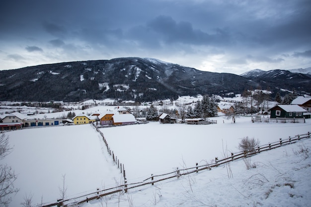 Schöne Landschaft der österreichischen Stadt im Tal bei den schneebedeckten Alpen