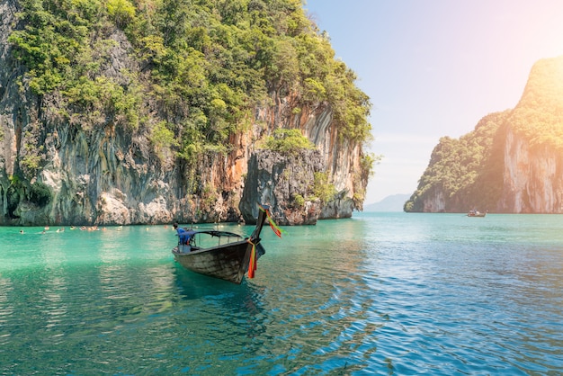 Schöne Landschaft des Felsenberges und des haarscharfen Meeres mit Longtailboot in Phuket, Thailand.