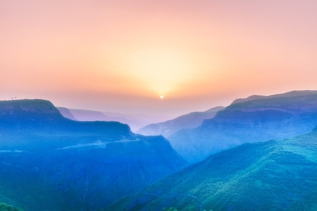 Schöne Landschaft mit grünen Bergen und herrlichem bewölktem Himmel bei Sonnenuntergang