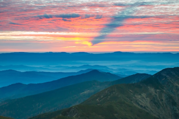 Schöne Landschaft mit Sonnenuntergang in den blauen Bergen